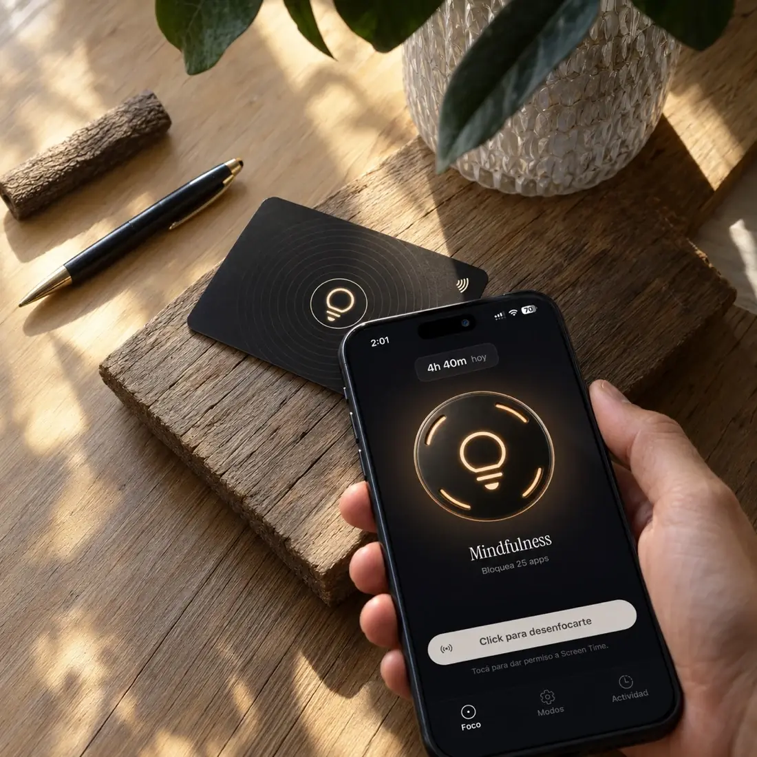 La tarjeta de Foco sobre una tabla de madera, con un teléfono apoyándose encima y la app abierta